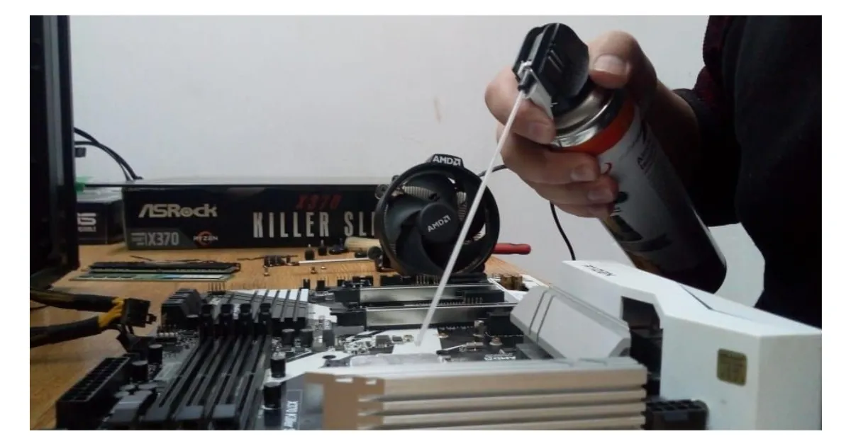 Limpieza con aire comprimido del cooler y la placa madre de una PC durante un mantenimiento